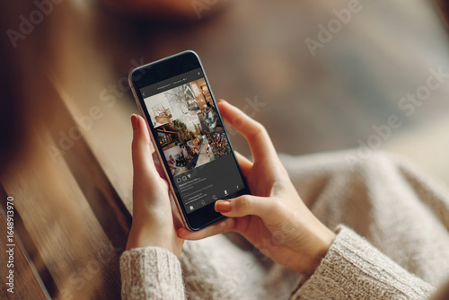 Woman scrolling through aesthetic social media feed on smartphone, finding inspiration for lifestyle.