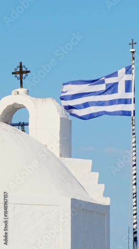 Wallpaper Mural The essence of a Greek landscape on Aegina Island. A whitewashed chapel in traditional style stands against a clear azure sky, with the national flag of Greece waving in the breeze. No people,vertical Torontodigital.ca