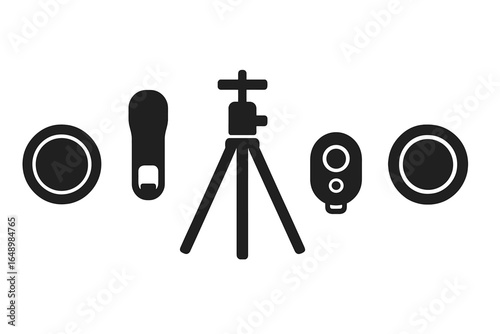 Camera accessories arranged around a tripod with remote and lenses on a white background