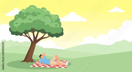 Man Relaxing On Picnic Blanket Under Shady Tree In Tranquil Landscape
