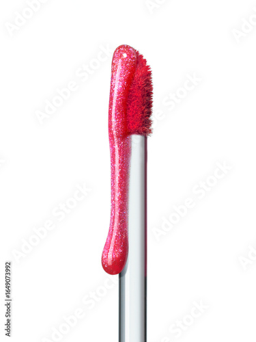 Shimmering pink lip gloss texture dripping down brush isolated on white background. Smudged cosmetic product smear. Makeup swatch product sample