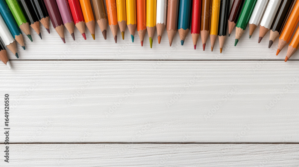 Obraz premium Colorful pencils arranged on white wooden surface create vibrant and artistic display
