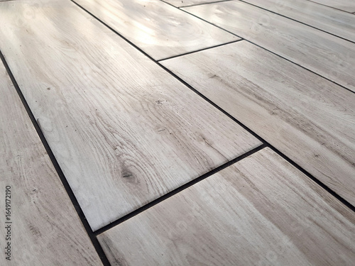 Floor covered with ceramic tiles with grout in between.