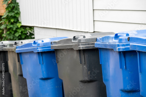 A row of recycling and garbage bins