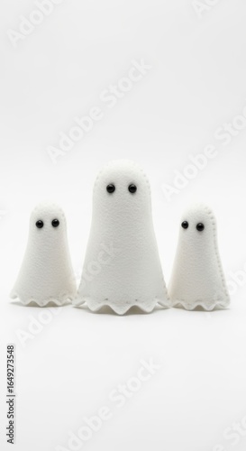 Hand-crafted felt ghosts on a solid white background, handmade miniature