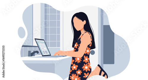 A young woman in a floral dress works on her laptop in a bright, modern bathroom setting.