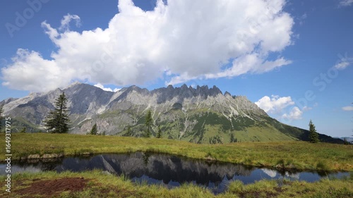Hochkönig mountain ridge in Austria. Alps mountains beautiful landscape. Austrian Alps in Salzburg region Salzburger almenweg hiking trail scenic video timelapse of clouds moving above Hochkonig ridge