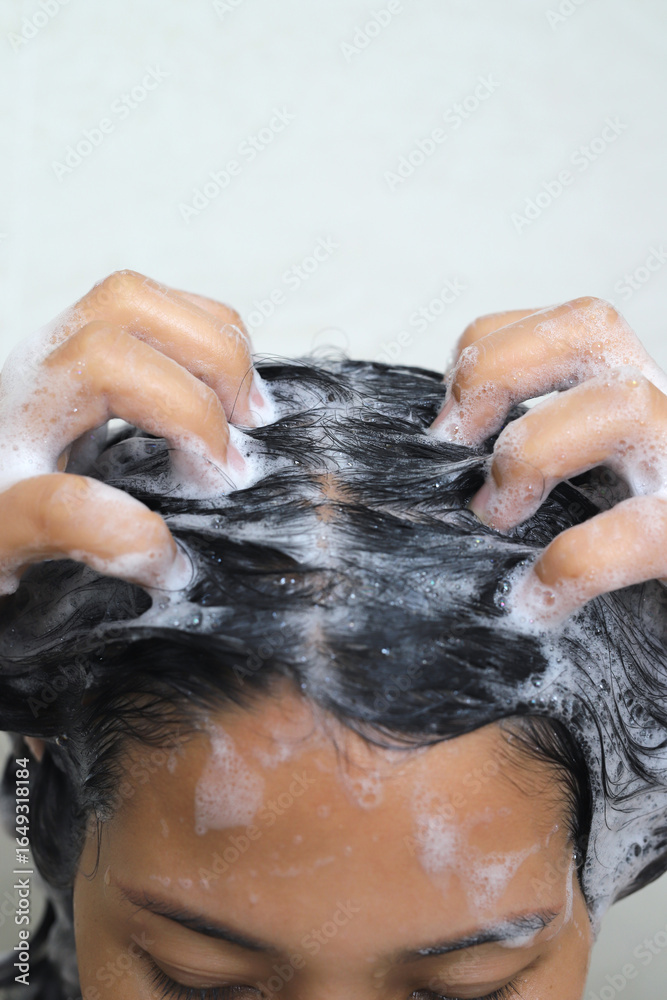 Naklejka premium A woman takes a shower and washes her hair in the bathroom at home.