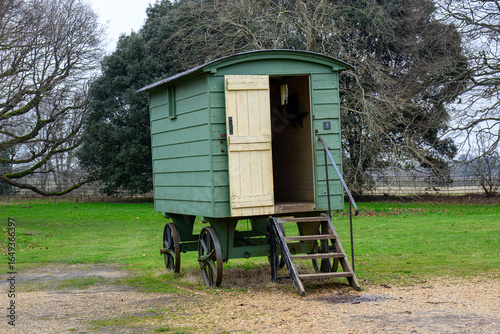 Tableau sur toile close up of a rustic green shepherds hut with trees in the background