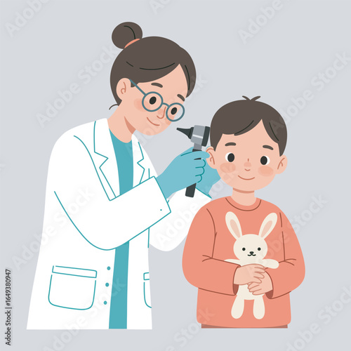 Friendly pediatrician checking young boy's ear with otoscope during medical examination
