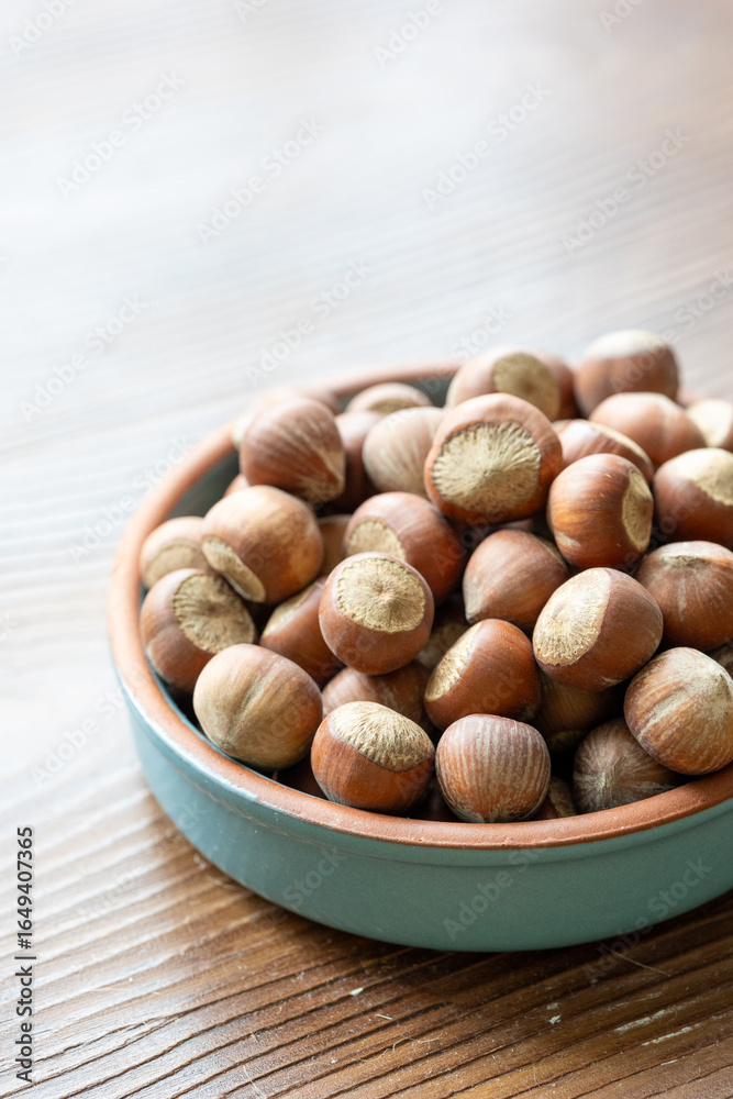 Fototapeta premium Fresh Turkish hazelnuts in shell in bowl in close-up