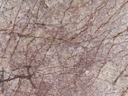 A textured surface featuring intricate patterns of light and dark shades, resembling natural stone or marble with fine veins.