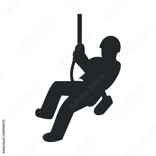 Silhouette of a person rock climbing with harness and rope