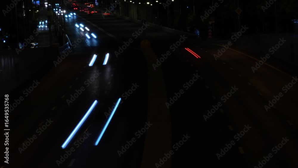 Dynamic night city traffic captured with long exposure, showing vivid light trails of white headlights and red taillights on a busy urban highway. The glowing lines create a striking contrast against Dynamic night city traffic captured with long exposure, showing vivid light trails of white headlights and red taillights on a busy urban highway. The glowing lines create a striking contrast against