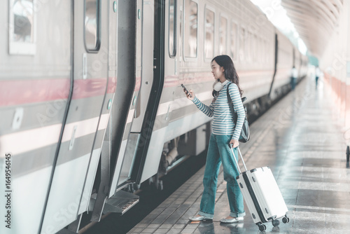 Photography Young Asian woman traveler with luggage at train station with travel concept, wo