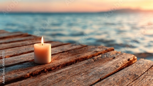 A tranquil scene featuring a lit candle resting on a wooden dock, overlooking the gentle waves of the sea as the sun sets in the background, creating a peaceful atmosphere.