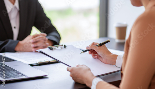 ビジネスミーティングでメモを取るビジネスウーマンの手元、ヒアリングをしているシーン