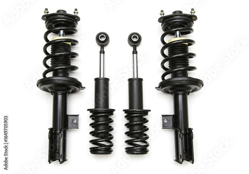 A studio shot showcasing four black car suspension components arranged on a white background surface