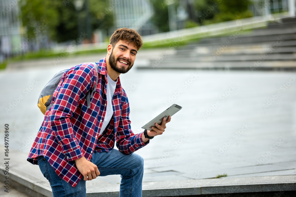Obraz premium Male Student Using Tablet on College Campus