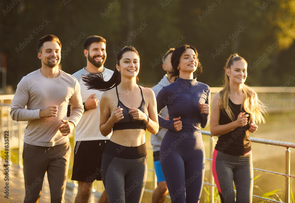Fototapeta premium Confident fit team of runners training together and running marathon, workout and challenge of active athletes group in summer park. Jogging action of strong fit people outdoor. Sport concept