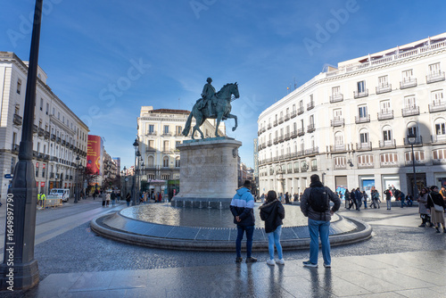 Plaza View: Capturing the spirit of city, the statue in the heart of the plaza. The sky, buildings, and people evoke a sense of urban life and history.