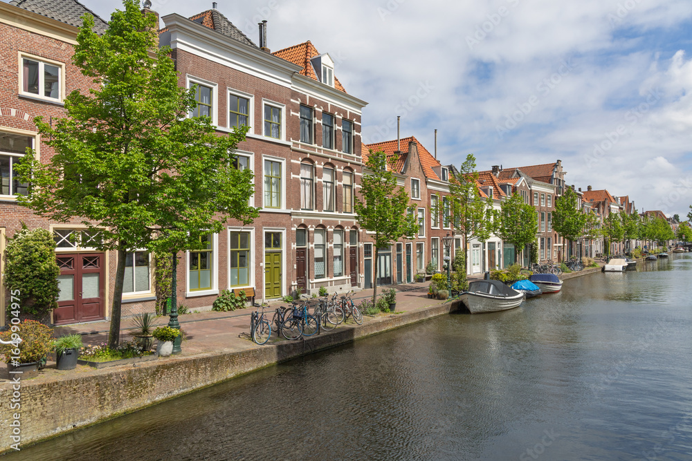 Φωτογραφία Beautiful canal scene in Leiden, Netherlands, featuring historic gabled houses, tree-lined quays, and serene boats