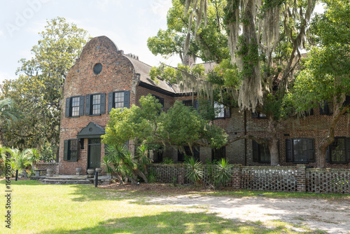 Charleston, South Carolina, USA - July 1, 2025: Historic brick mansion at Middleton Place Plantation with live oaks and Spanish moss in summer light.