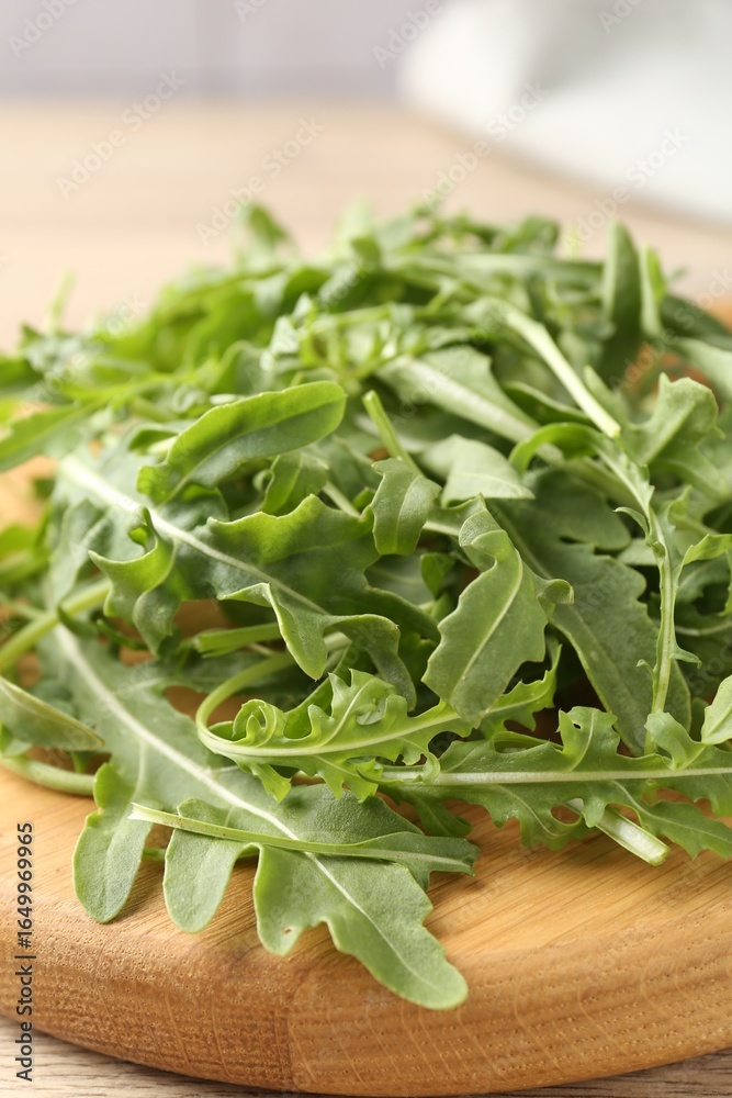 Fresh ripe green arugula leaves on light wooden table, closeup Fresh ripe green arugula leaves on light wooden table, closeup