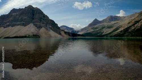 Moving panoramic view of mountain reflection in an alpine lake