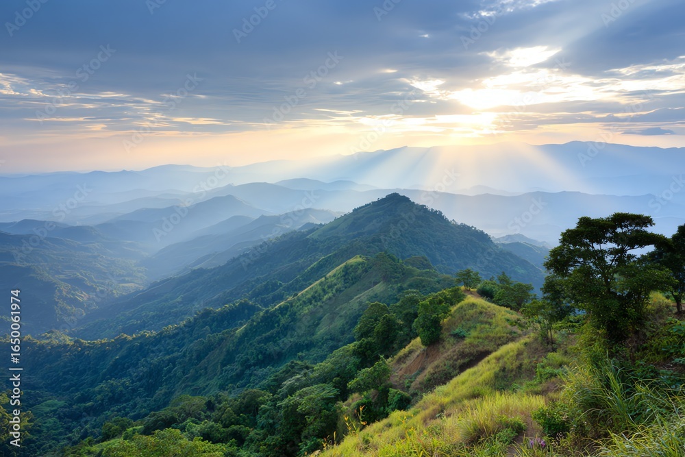Obraz premium Golden sunlight breaks through dramatic cloud formations, illuminating a vast, rolling mountain landscape covered in lush green vegetation, evoking a sense of peace and grandeur.