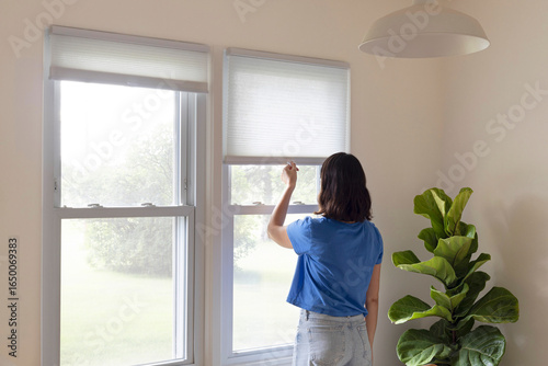 Woman closing the blinds 