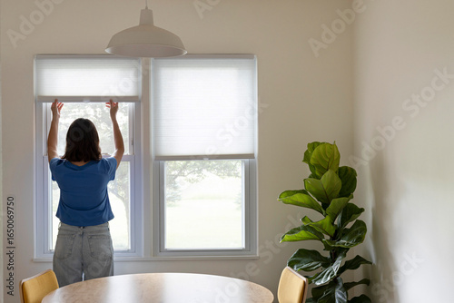 Woman opening window shades