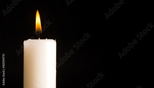 Single white candle with burning flame against a black background.