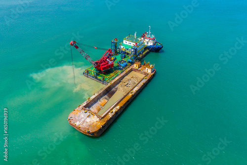 Obraz na płótnie Industrial dredging barge in offshore construction project with tugboat support