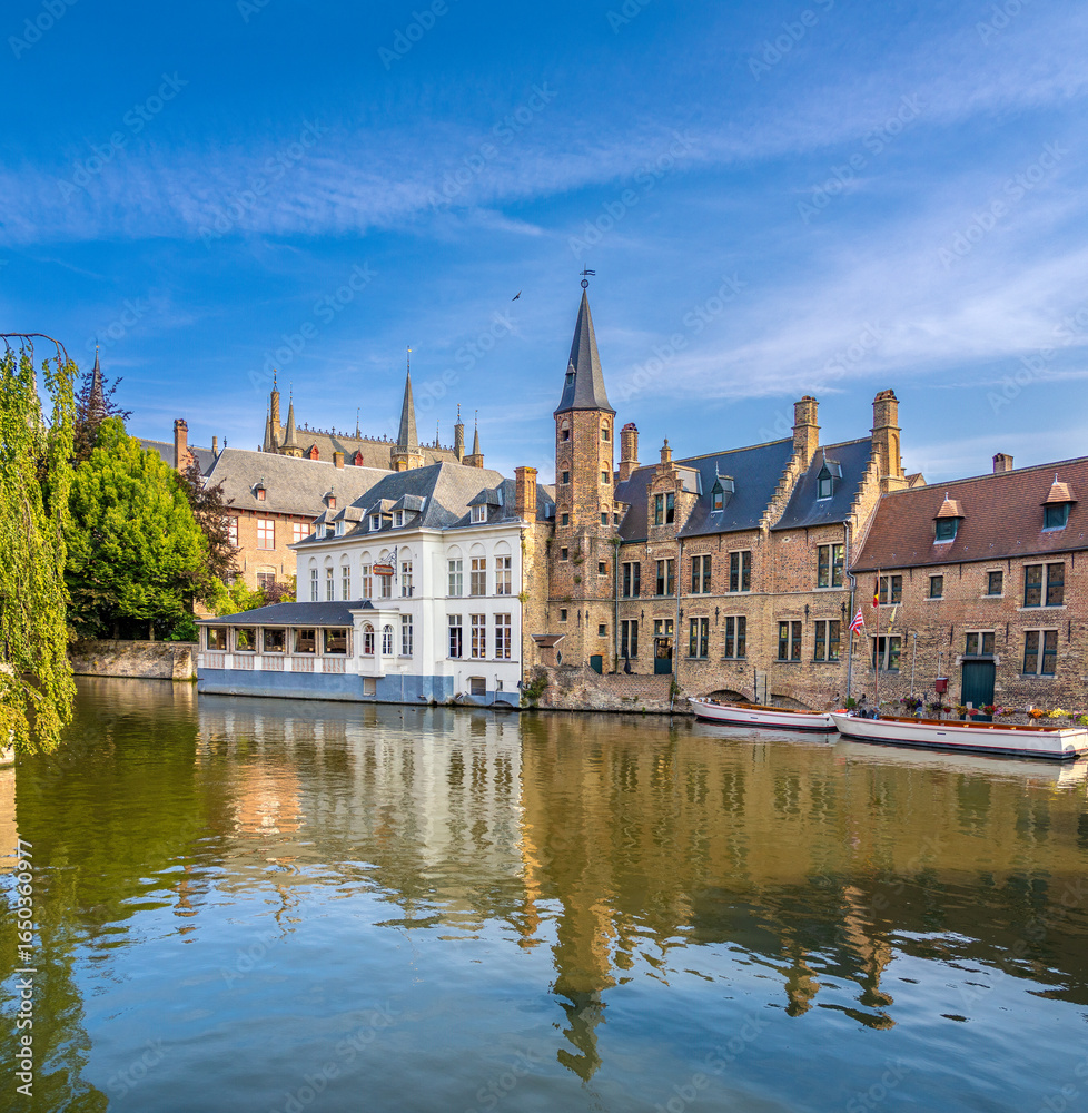 Naklejka premium Boat tour of the picturesque canals of the old city of Bruges (Brugge), East Flanders, Belgium