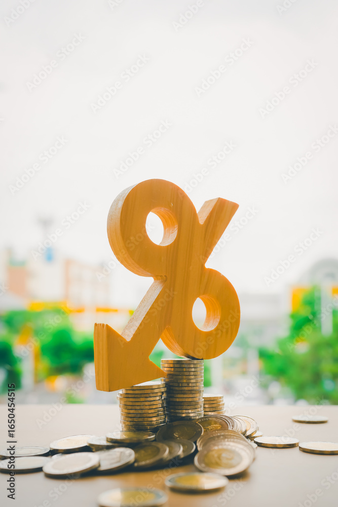 Φωτογραφία Wooden percent symbol with a downward arrow on coins represents decreasing interest rates, lower mortgage costs, and improved loan conditions
