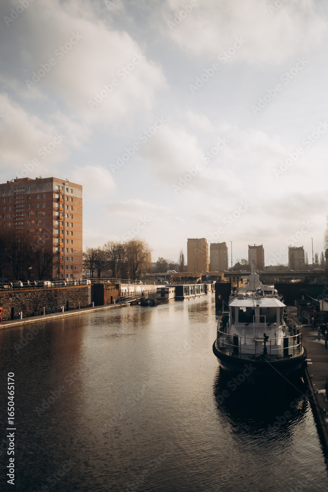 Naklejka premium A boat is floating on a river near a city