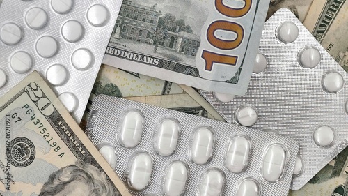 Background view of a white medical tablets over a 20 and 100 US dollar bills, symbolizing the high cost of healthcare, pharmaceutical expenses, medical industry profits, and economic burden.