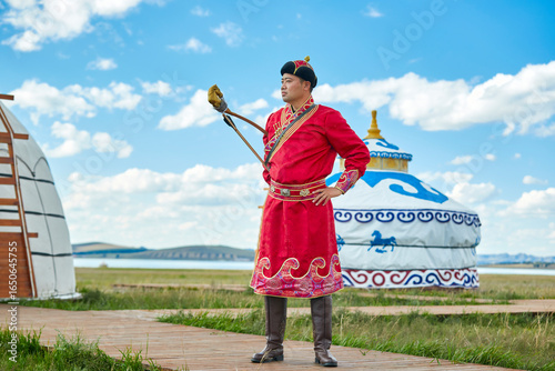 Φωτογραφία Mongolian men dressed in traditional Mongolian attire and holding bows and arrows stand in front of a yurt