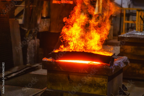 Molten metal from a metallurgical furnace burns with a bright red flame
