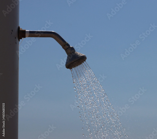 Beach shower pouring refreshing water on a sunny day