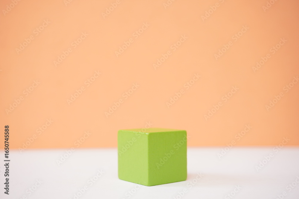 Obraz premium Green wooden cube on a gradient background ideal for educational or abstract concept visualizations