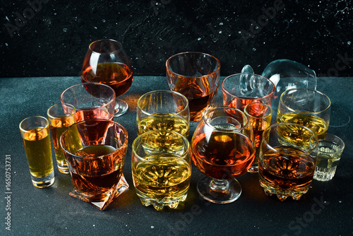 Fotografia A set of glasses with various alcoholic beverages: vodka, cognac, tequila, scotch, brandy and whiskey, grappa, liqueur, vermouth, tincture, rum