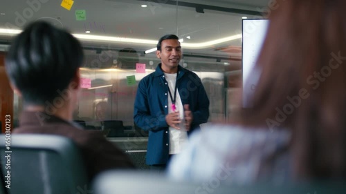 Confident Indian Businessman presenting ideas discussing strategy analysis financial data charts and graphs report on screen monitor with colleagues in boardroom office. Corporate Business meeting.