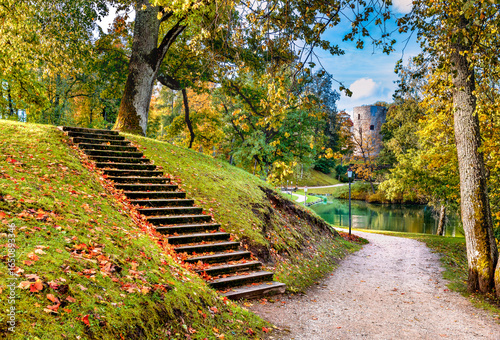 Golden autumn in old public  park with pedestrians walkways, stairs on the hi...