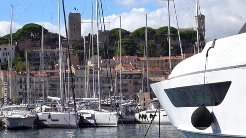 Distant view from the Old Port of a Cannes sign written on a mountain near the Notre Dame d'Esperance church and the Museum of World Explorations