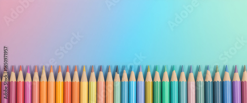 Colorful pastel pens lined up on gradient background in rainbow arrangement