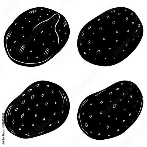 Four black and white potatoes with varying textures and patterns displayed on a white background surface