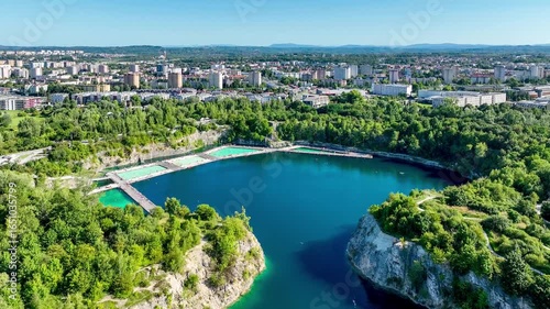 Krakow, Poland. Zakrzówek swimming pools, sunbathing platforms and paddling area on Zakrzowek lake with steep cliffs in place of flooded limestone quarry. Public recreational place. Aerial video