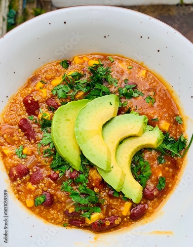 Healthy Quinoa Chili Bowl with Avocado Garnish and Fresh Herbs